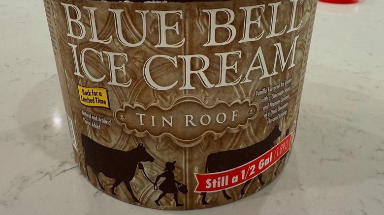 A carton of Blue Bell Tin Roof ice cream on a counter