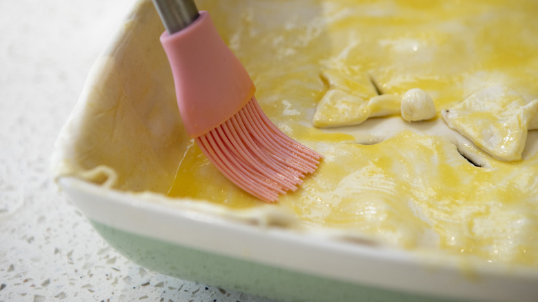 Egg wash being brushed onto pastry