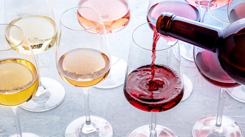 An assortment of wine being poured into wine glasses