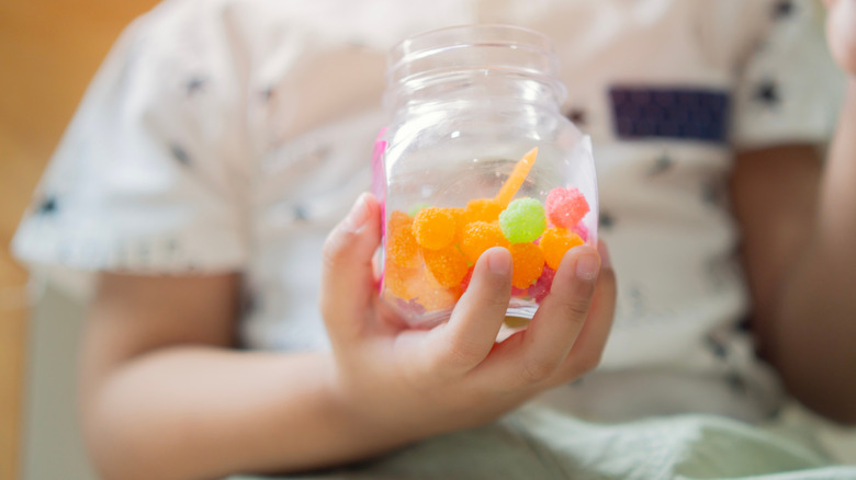 kid holding candy jar