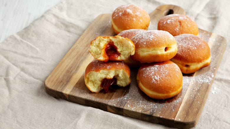 Pile of jam-filled pączki on a wooden board