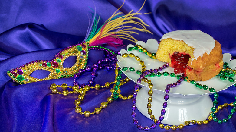 Pączki on a white platter decorated for Mardi Gras