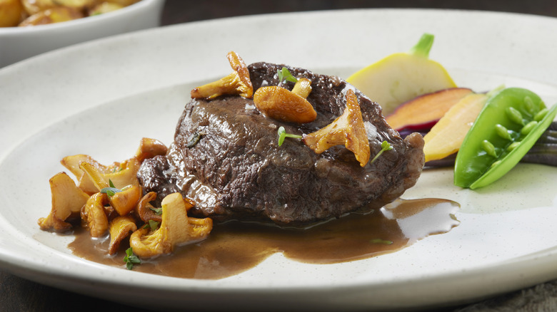 Beef cheek and mushrooms on a white dinner plate