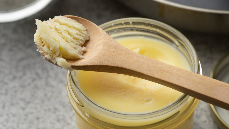 Ghee on a spoon over a jar