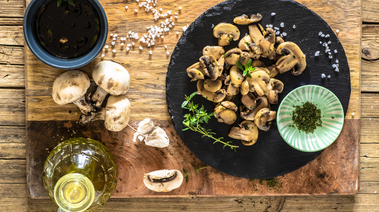 Mushrooms served with parsley and garlic on a black plate