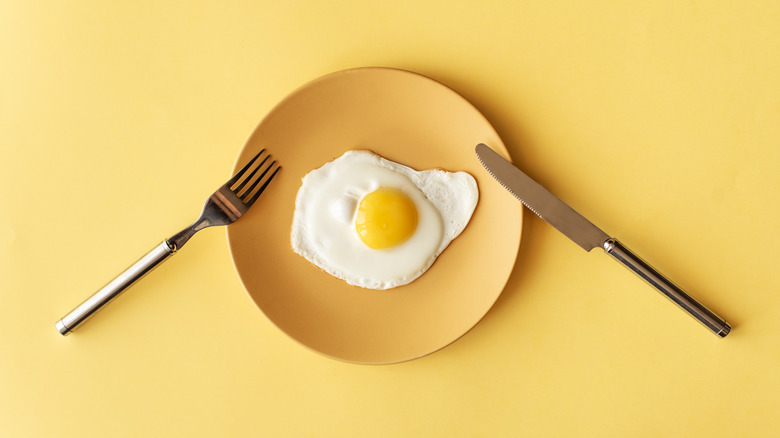 Fried egg on yellow background and top view