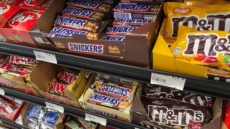 A candy aisle shelf displaying a range of chocolate bars