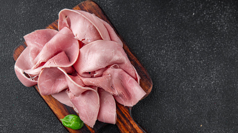 Wood platter of ham slices with a garnish