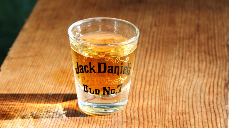 A Jack Daniel's Old No. 7-branded shot glass with whiskey in it