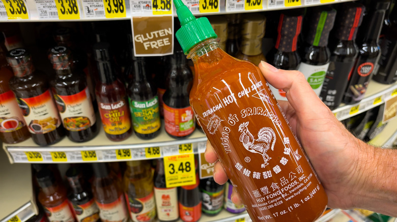 Hand holding sriracha