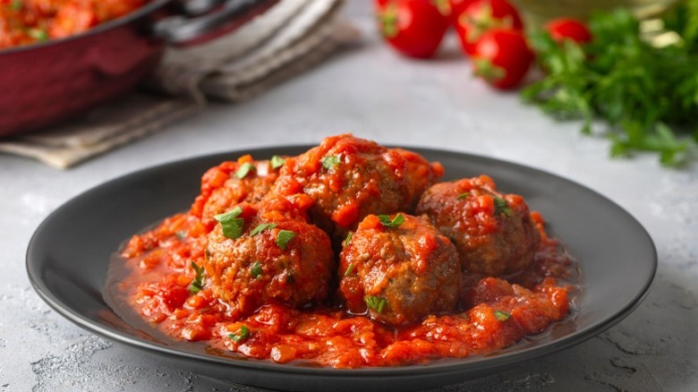 A plate of meatballs with tomato sauce over the top