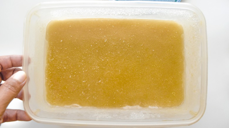 a block of frozen solid soup in a plastic container