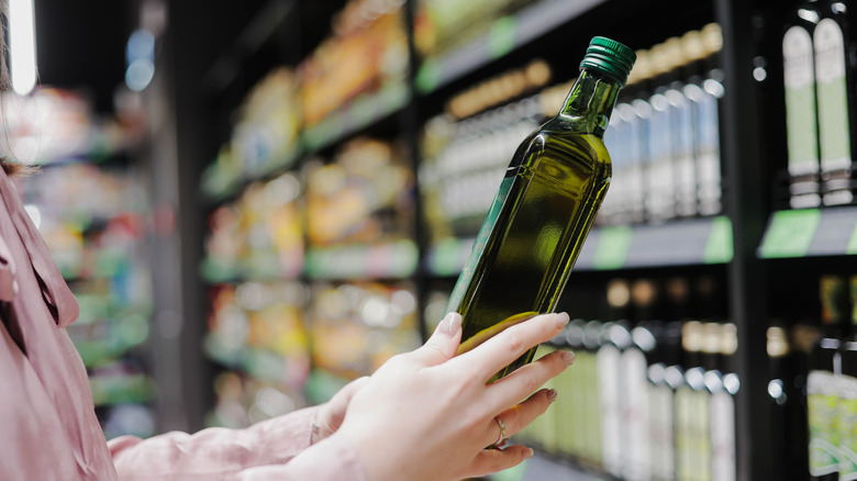 buying a bottle of olive oil at supermarket