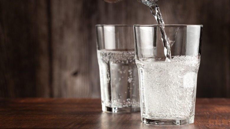 A glass of sparkling water being poured.