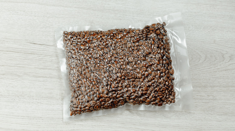 A clear, vacuum-sealed bag of coffee beans