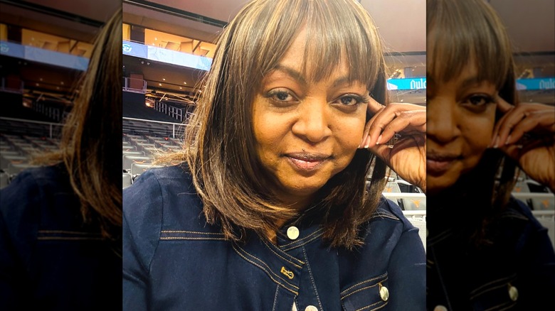 Fran Harris poses in front of a basketball court