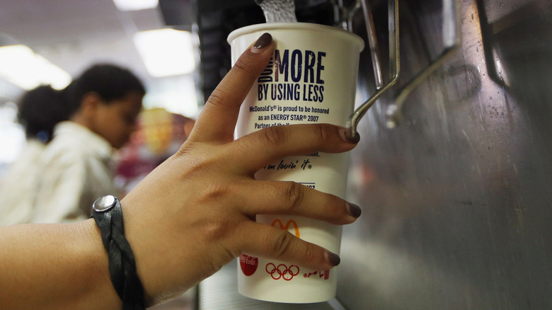 Hand using soda machine at McDonald's