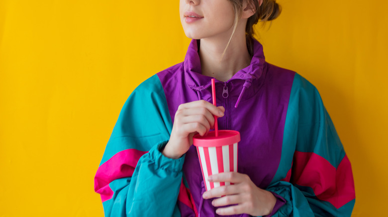 Young woman holds soda cup