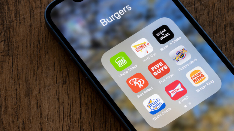 A smartphone showing various food ordering apps including Fuddruckers
