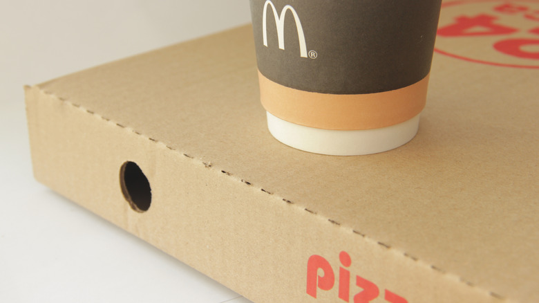 The bottom of a McDonald's coffee cup sits on a pizza box