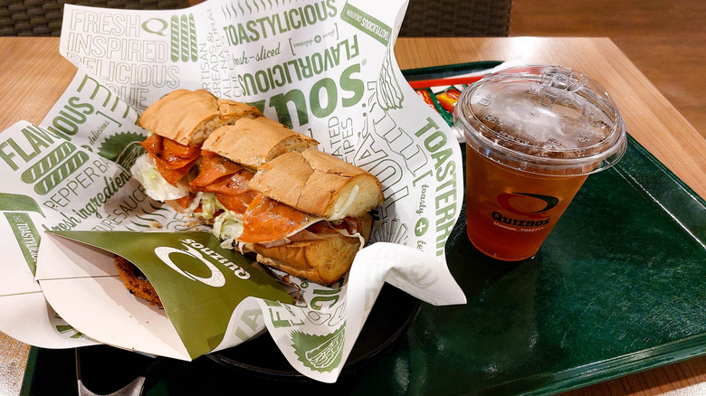 A tray with a Quiznos sub and a Quiznos drink