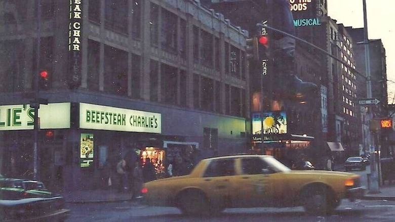 Street view of the original Beefsteak Charlies with a taxi going past it