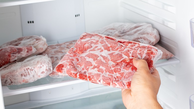 man holding frozen meat bag freezer