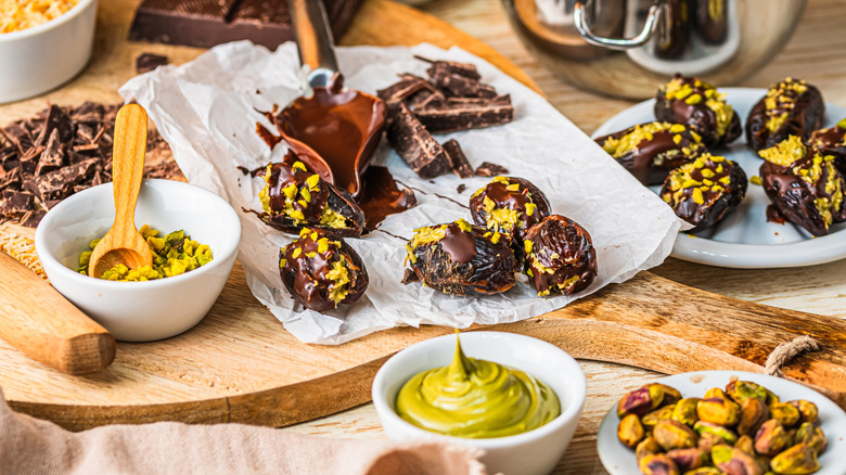 A workstation where pistachios, pistachio cream, and chocolate and being combined into Dubai chocolate bites