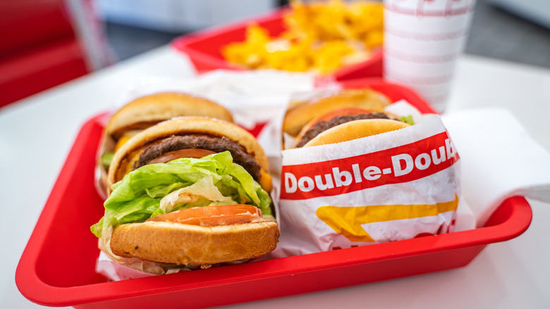 Red tray with several In-N-Out burgers on it