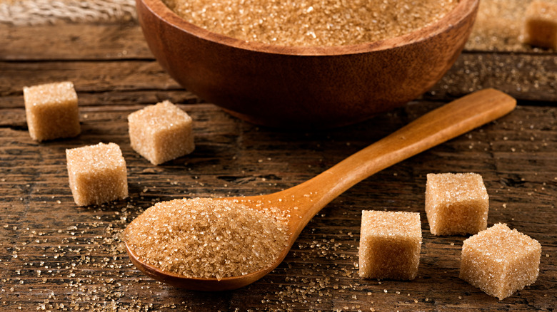 brown sugar in a wooden bowl and spoon and brown sugar cubes