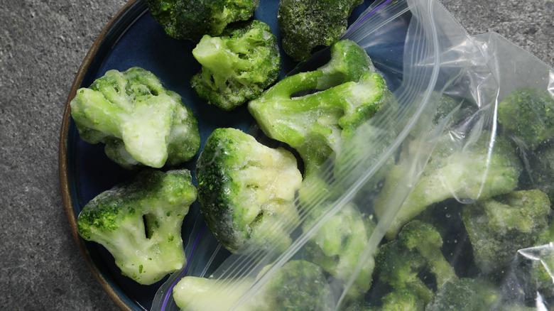 frozen broccoli florets spilling out of a bag