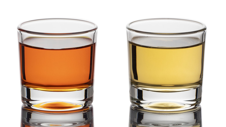 Aged tequila in glass cups on a white background, with extra añejo on the left and añejo on the right