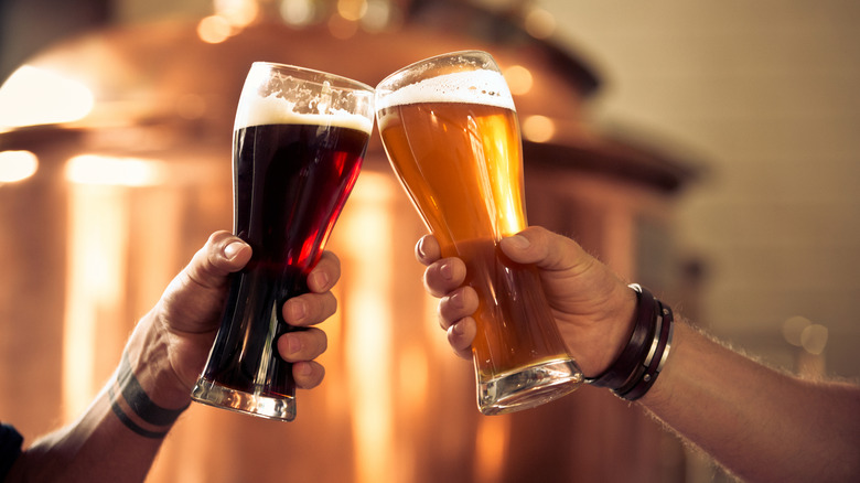 A toast with an ale and a lager in beer glasses.