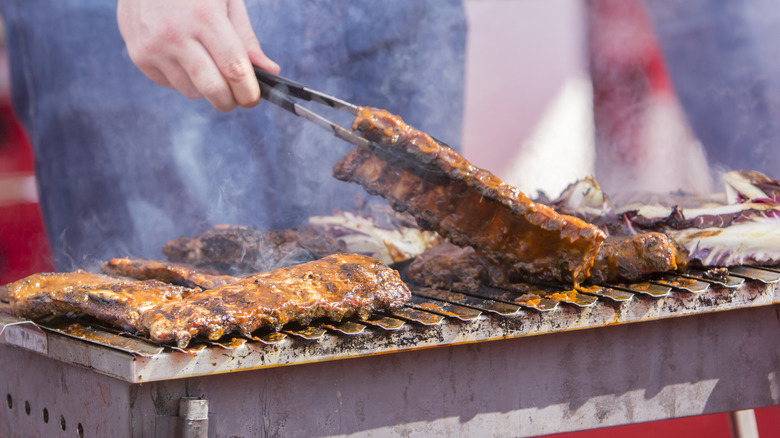 Someone grilling pork ribs on the grill