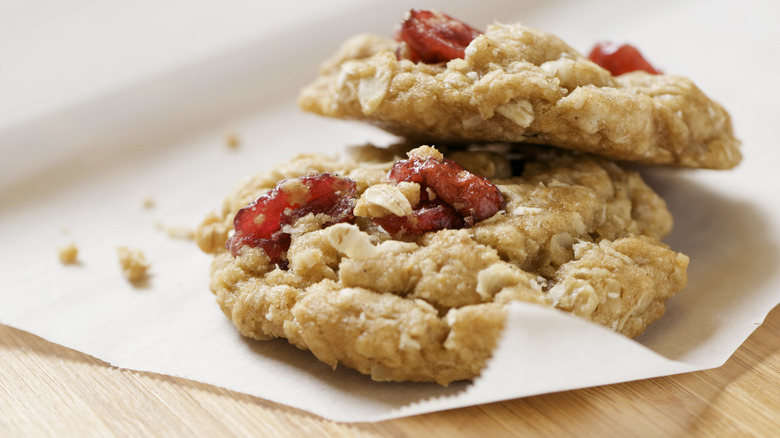 Two oatmeal cookies on wax paper