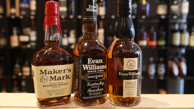 Several varieties of American bourbon whiskey sitting on a shelf.