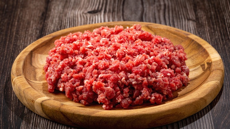 Raw ground beef on a wooden platter