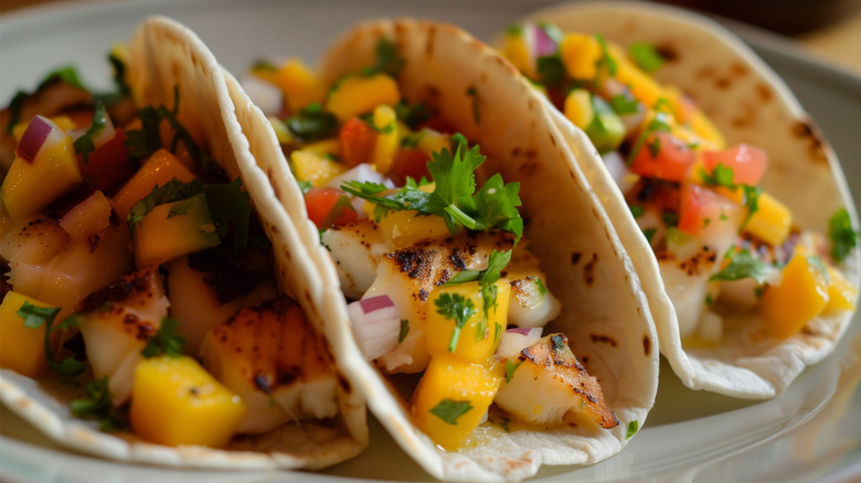 Plate of three grilled fish tacos with mango salsa