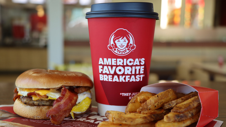 Wendy's Breakfast Baconator, Fries, and a cup of coffee sit on a table