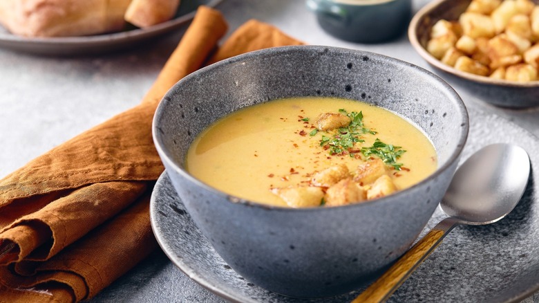 A bowl of mashed potato soup with a spoon