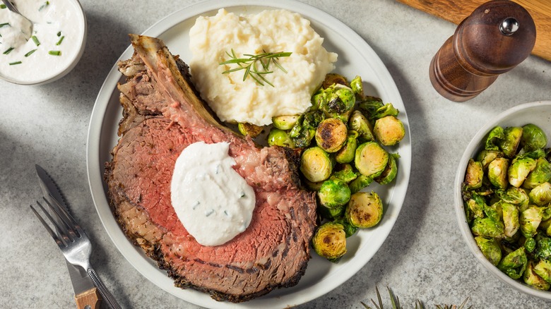 slice of prime rib with horseradish cream and potatoes