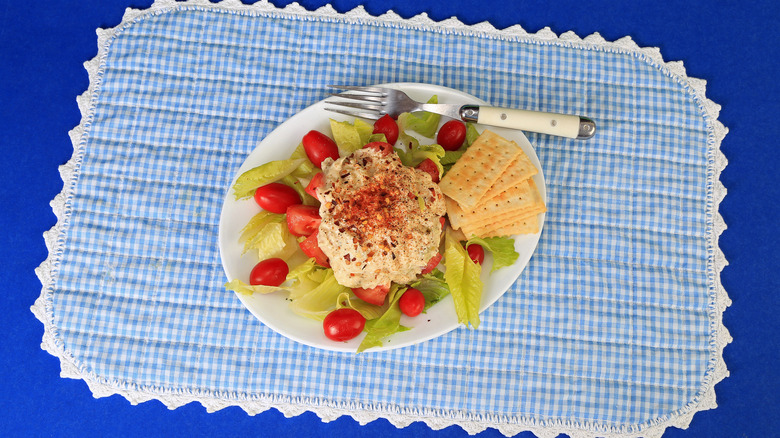 Scoop of tuna salad on lettuce and tomatoes with crackers