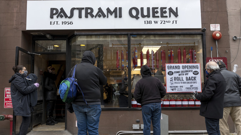 A crowd gathers outside a new location of Pastrami Queen in Manhattan, where Anthony Bourdain's favorite pastrami on rye sandwich is made