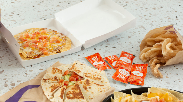 Taco Bell's Veggie Mexican pizza, crunch wrap and cinnamon twists sitting on a table.