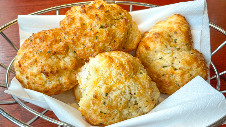 Four Red Lobster Cheddar Bay biscuits on napkin in a metal basket