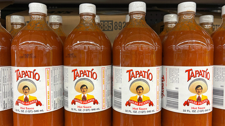 Multiple bottles of Tapatío brand hot sauce on a grocery store shelf