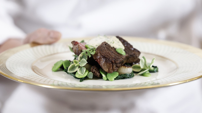 White House chef holding plate with steak and greens