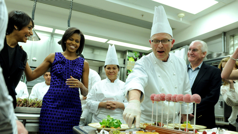 Michelle Obama smiles as Bill Yostes prepares pastry in White House kitchen