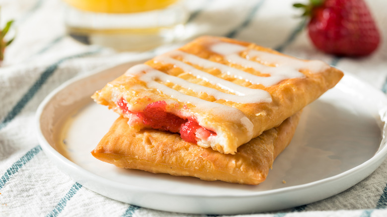 Fruit filled pastry with icing on white plate