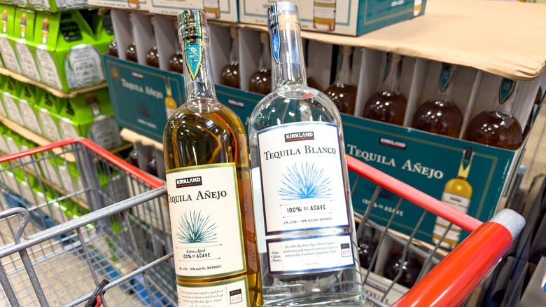 Two bottles of Kirkland brand tequila in a shopping cart